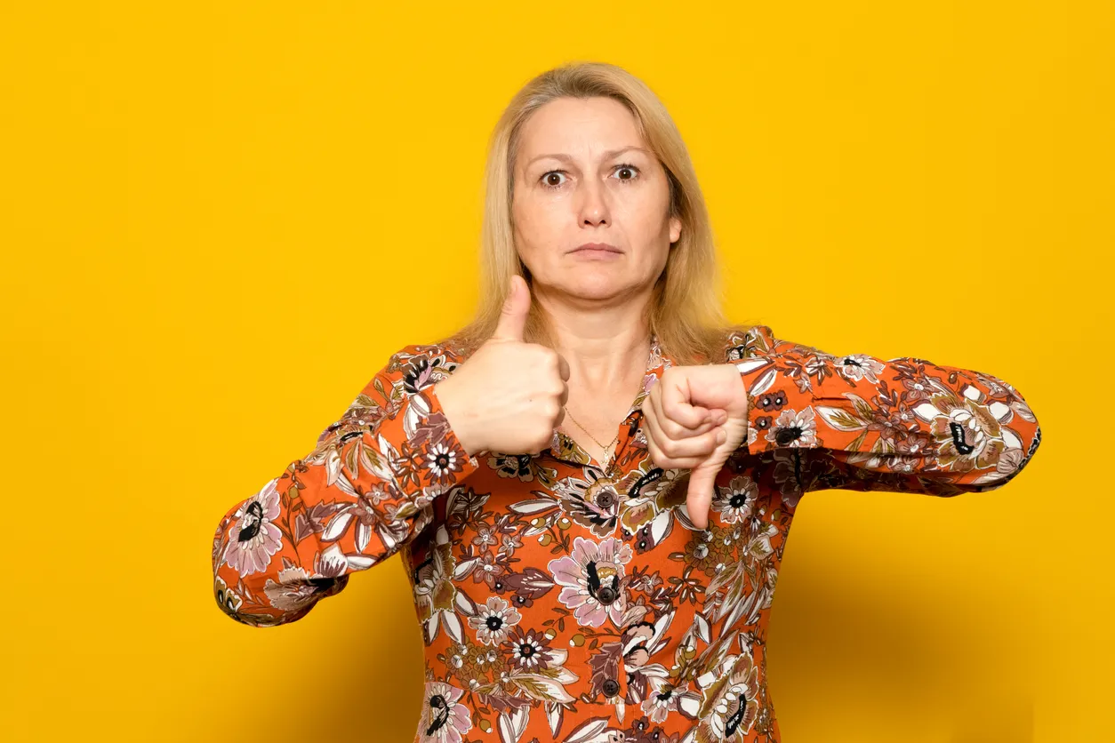 A woman with one thumb pointing up and the other pointing down.